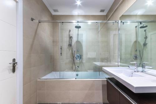 a bathroom with a tub and a sink and a shower at Azkuna Comfort Bilbao in Bilbao