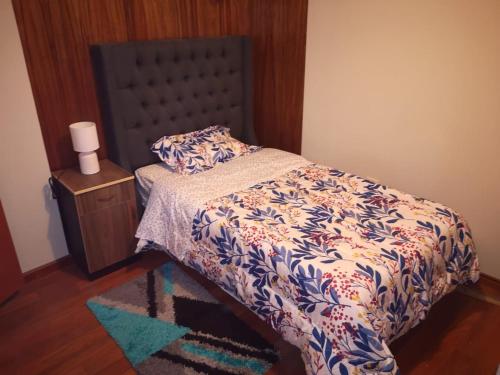 1 dormitorio con 1 cama con edredón azul y blanco en Miski Wasi, en Puno