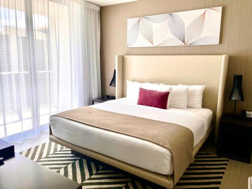 1 dormitorio con cama grande y almohada rosa en Hyde Beach House Grand Sea View en Hollywood