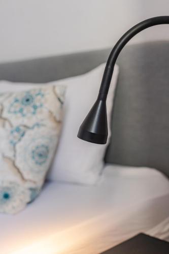 a black lamp on a white couch with a pillow at Hostal El Perelló, Valencia in El Perelló