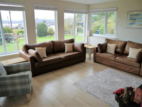 uma sala de estar com dois sofás castanhos e um tapete em Firpoint em Rockcliffe
