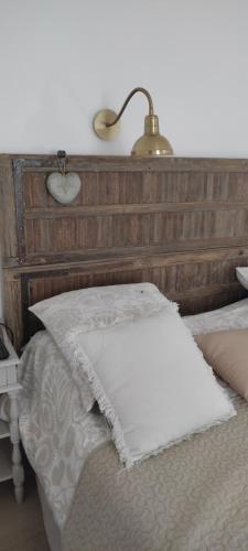 a bedroom with a bed with a wooden headboard at Chambre d'hotes Mas Pékin in Mas-Thibert