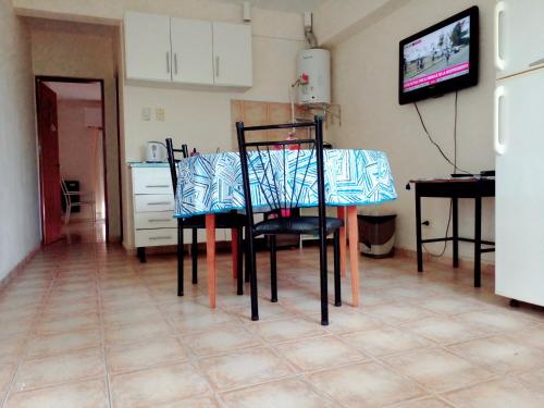 a table and chairs in a kitchen with a television at Buenos Aires Tango Apartment near Golf in San Antonio de Padua