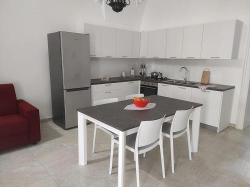 een keuken met een tafel en stoelen en een koelkast bij Casa Cesira in Casamassella