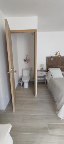 a bedroom with a bed and a bathroom with a toilet at Chambre d'hotes Mas Pékin in Mas-Thibert