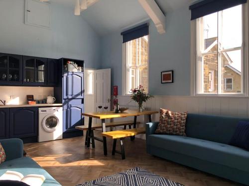 sala de estar con sofá azul y mesa en Escape To The Country @ Bron Offa Bach en Coedpoeth
