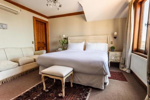 a bedroom with a large white bed and a couch at Gervasoni Hotel Boutique in Valparaíso