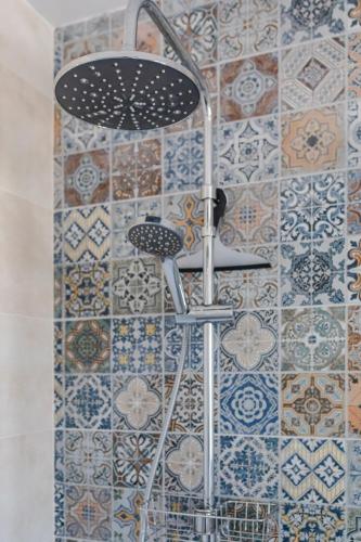 a shower in a bathroom with tiles on the wall at Hostal El Perelló, Valencia in El Perelló