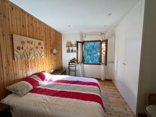 Schlafzimmer mit einem Bett mit einer roten und weißen Decke in der Unterkunft Piso Rialp con vistas in Rialp