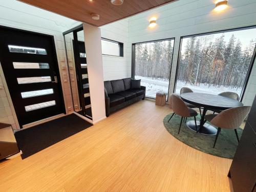 uma sala de estar com uma mesa e cadeiras e um sofá em Arctic Iglu Levi em Sirkka