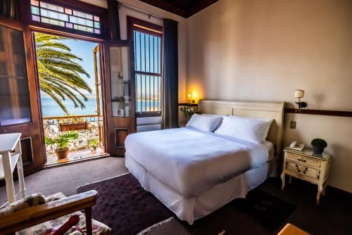 een slaapkamer met een groot wit bed en een raam bij Gervasoni Hotel Boutique in Valparaíso