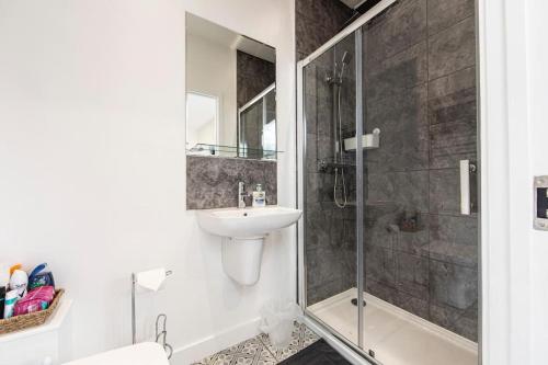 a bathroom with a sink and a glass shower at Ty Bunc Ffrwdwen in Treharris