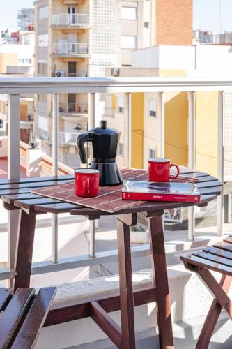 a table with two red cups on a balcony at Hostal El Perelló, Valencia in El Perelló