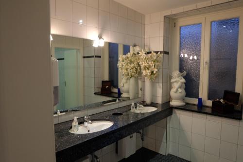 a bathroom with two sinks and a large mirror at Hotel Zum Weißen Roß in Winsen Luhe