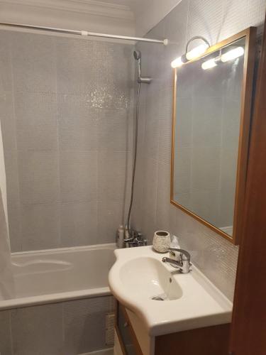 La salle de bains est pourvue d'un lavabo, d'une baignoire et d'un miroir. dans l'établissement Apartamento do Paço do Lumiar, à Lisbonne