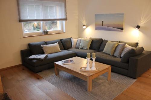 uma sala de estar com um sofá e uma mesa de centro em kleineauszeit3, Feldberg, direkt an Skipiste, mit Sauna em Feldberg