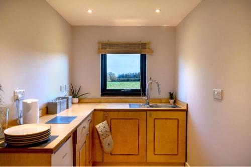 a kitchen with a sink and a window at Sol Lodge & Boutique Spa in Kent