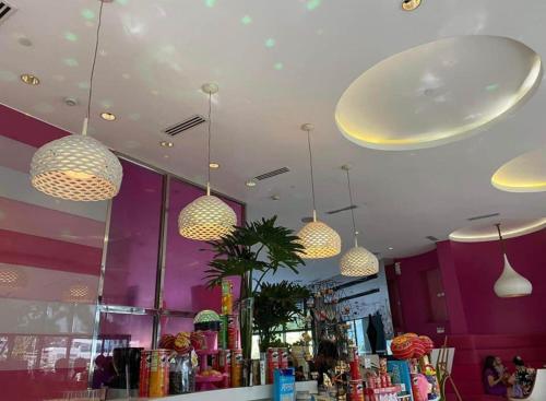 een restaurant met verschillende lampen aan het plafond bij Azure south urban beach resort near airport in Manilla