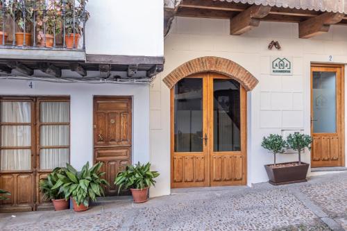 a building with wooden doors and potted plants at ANJ Alojamientos in Guadalupe