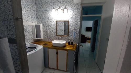 a bathroom with a sink and a washing machine at Cozy vacation retreat with free parking in Roseau