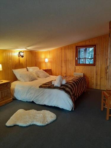 - une chambre avec un grand lit et 2 tapis au sol dans l'établissement RESIDENCE LE RUITOR Duplex dernier étage vue panoramique piscine chauffée en été classé 4 Cristaux Paradiski, à Arc 1800