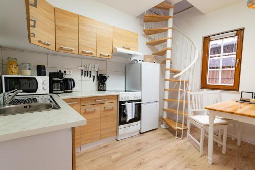 a kitchen with white appliances and wooden cabinets at Charmantes denkmalgeschütztes Tiny House am Rhein in Rhens