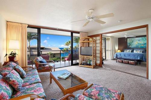 a living room with a couch and a bed and a television at CASTLE at Makahuena at Po'ipū in Koloa