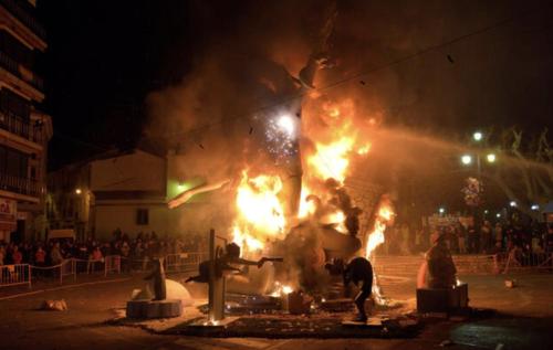a group of people standing around a building with fire at Casa Conxin Beach & Mountain Apartment Costa Blanca in Pego
