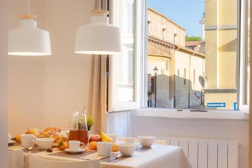 una mesa con tazas y naranjas con una ventana en Colosseum Holidays - San Giovanni in Laterano, en Roma