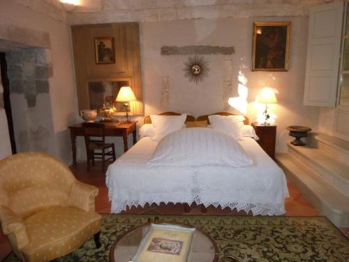 ヴィルヌーヴ・レ・ザヴィニョンにあるLe Cloitre du Couventのベッドルーム(白いベッド1台、椅子付)