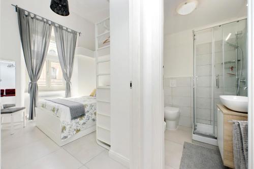 a white bathroom with a bed and a sink at CASTRO PRETORIO SUITE - 1 bedroom flat, 2nd floor with lift, comfortable, quite, central, 2 steps from Termini Railway Station and metro A and B lines, a walk from Colosseum, Trevi Fountain, Spanish Steps, free welcome drinks in Rome