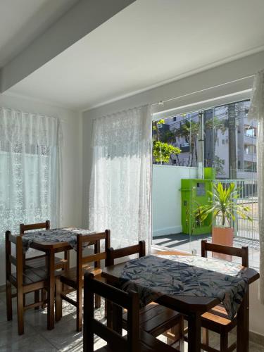 een eetkamer met 2 tafels en stoelen en een raam bij Pousada Serrate in Ubatuba