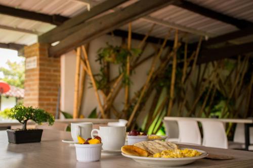 una mesa con un plato de comida y pan. en Finca Hotel Casa Nostra, Villa Manuela, en Quimbaya