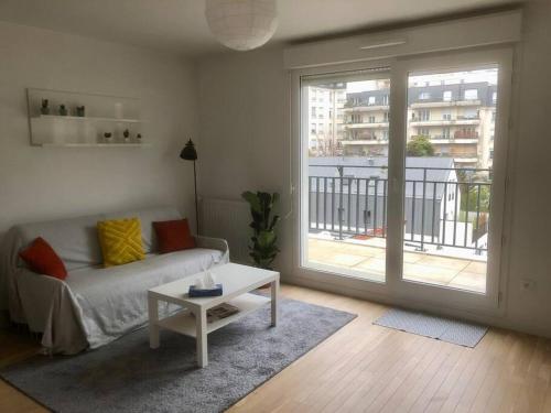 a living room with a couch and a table at Charmant appartement à la limite de Paris in Villejuif