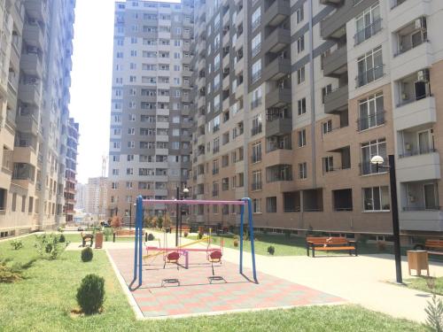un parque infantil en una ciudad con edificios altos en Gold Baku, en Baku