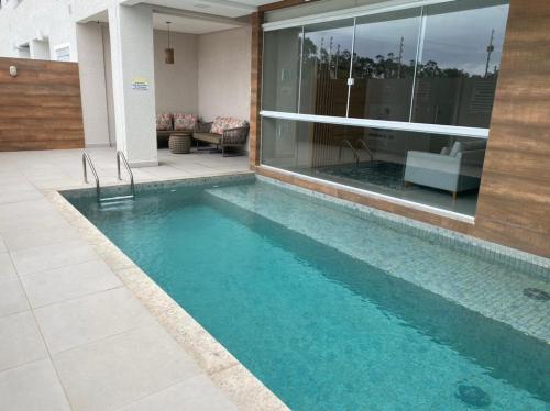 una piscina frente a una casa en Apartamento aconchegante a 200 metros da praia, en Florianópolis