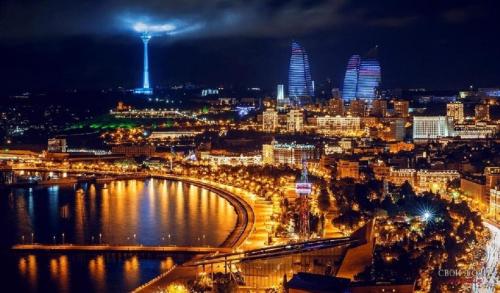 a view of a city at night with a river at Gold Baku in Baku