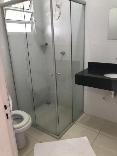 a bathroom with a glass shower and a toilet at Pousada Trilha do Sol in Pirenópolis