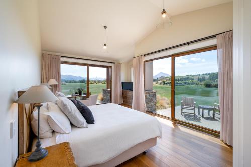 a bedroom with a large bed and a large window at Wanaka Haven in Wanaka
