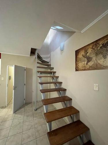 una escalera de madera en una habitación con una pintura en la pared en Departamentos San Rafael Ahora en San Rafael