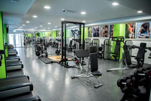 a gym with lots of machines and posters on the walls at Hotel Borovi Forest Resort & Spa in Sjenica