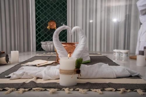 a table with towels and a candle on a table at Hotel Borovi Forest Resort & Spa in Sjenica