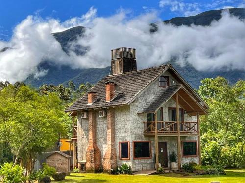 an old house with a mountain in the background at Pousada & Camping Nativos dos Canyons in Praia Grande