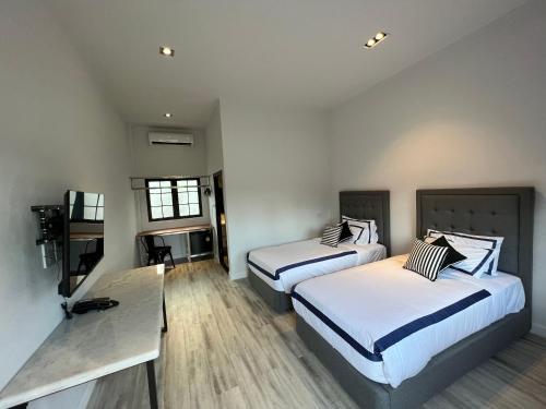 Habitación de hotel con 2 camas y mesa en Macchiato Resort Savannakhet Opposite Thai Embassy en Savannakhet