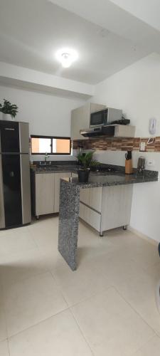 a large kitchen with a counter top in a room at Apartamento de verano cerca al parque del café in La Tebaida