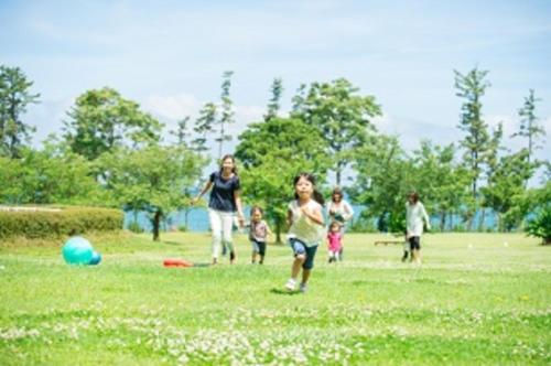 a group of people playing with a ball in a field at Kyukamura Echizen-Mikuni in Sakai