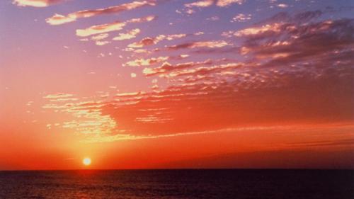 a sunset over the ocean with a cloudy sky at Kyukamura Echizen-Mikuni in Sakai