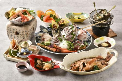 a table with many plates of food on it at Kyukamura Echizen-Mikuni in Sakai