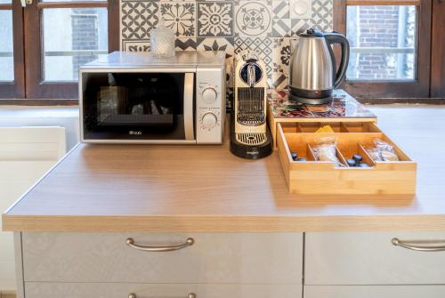 a microwave oven sitting on top of a kitchen counter at Au cœur de joigny in Joigny