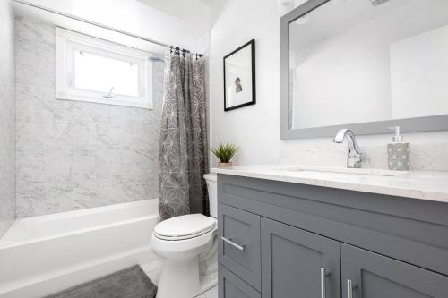 a bathroom with a toilet and a sink and a tub at Central 4 Bed Room Home by GO Station and Sq One! in Mississauga